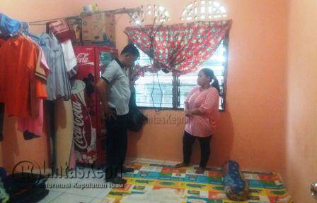 Terlihat seorang petugas kepolisian melakukan penyelidikan di kamar korban.