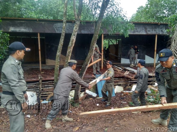 Anggota Satpol PP saat melakukan pembongkaran sebuah bangunan terbuat dari kayu tanpa IMB yang berdiri diatas kawasan Mangrove di Jalan Raja Haji Fisabilillah Km 8 Kota Tanjungpinang, Rabu (4/10).