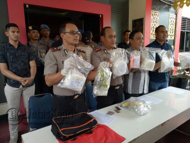 Polisi saat menunjukkan barang bukti sabu dan pil ekstasi berikut dua tersangka saat konferensi pers di Mapolres Tanjungpinang. 