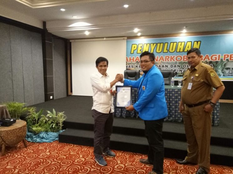 Ketua KNPI kota Tanjungpinang memberikan plakat kepada Arifin Majid sebagai Asisten deputi peningkatan wawasan pemuda deputi 1 pemberdayaan pemuda Kemenpora RI.