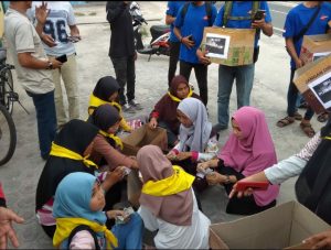 Para relawan penggalang dana saat menghitung hasil uang yang terkumpul dari para dermawan.