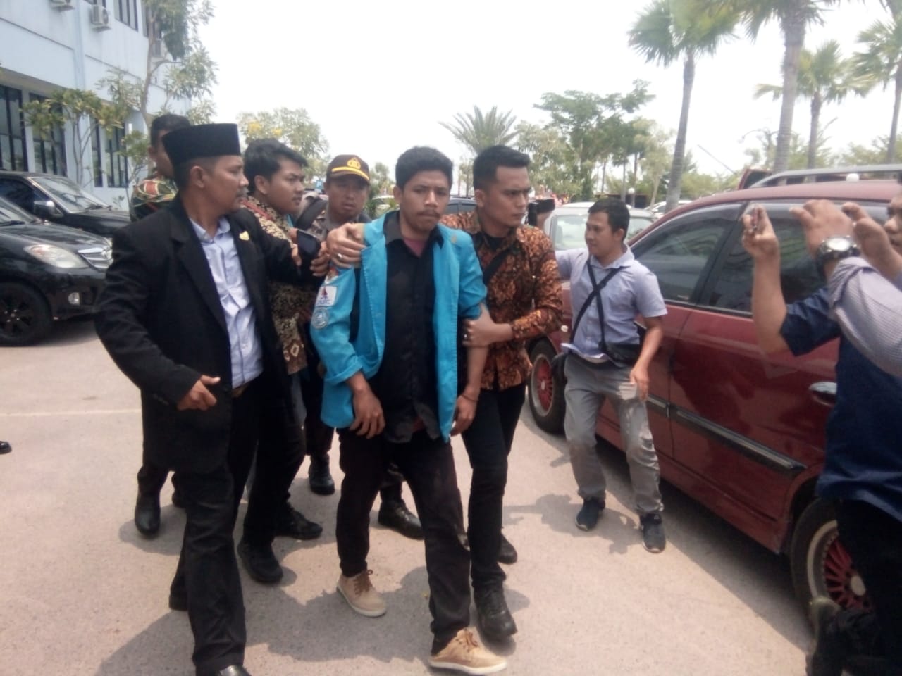 Salah seorang mahasiswa yang diamankan polisi atas aksi pembentangan spanduk bertuliskan Wakil Rakyat Ingat Janji Pada Rakyat, pada saat pelantikan anggota DPRD Kepri terpilih periode 2019-2024, Senin pagi. 