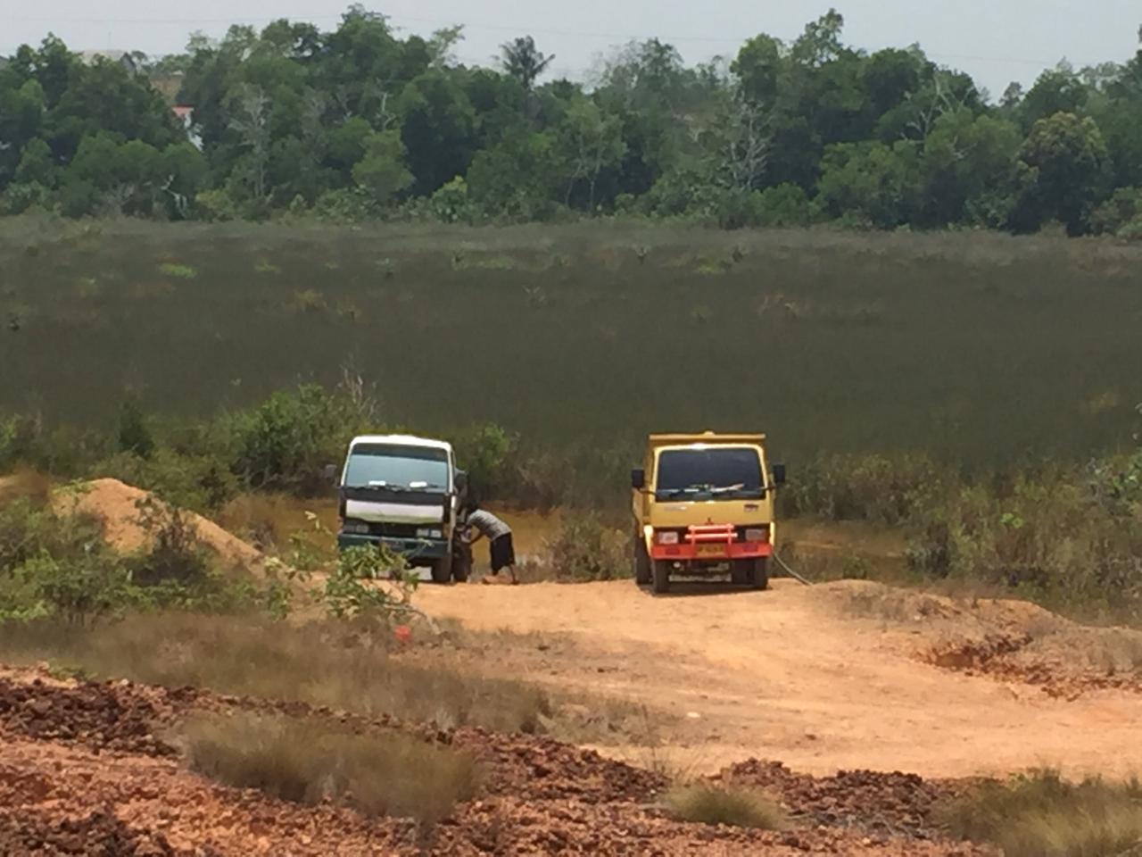 Dua kendaraan di lokasi bekas tambang bauksit Senggarang terlihat menyedot air.