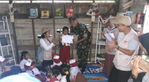 Babinsa Koramil 03/Sedanau memberikan buku kepada anak sekolah SD di Segeram.