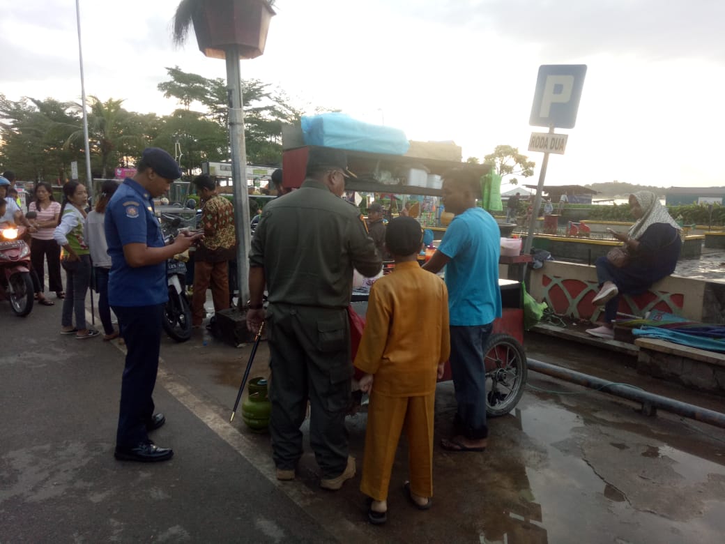 Kepala Satuan Polisi Pamong Praja dan Penanggulangan Kebakaran Kota Tanjungpinang Hantoni saat menjelaskan kepada pedagang tentang larangan berjualan di Taman Laman Boenda, Jumat (20/12).