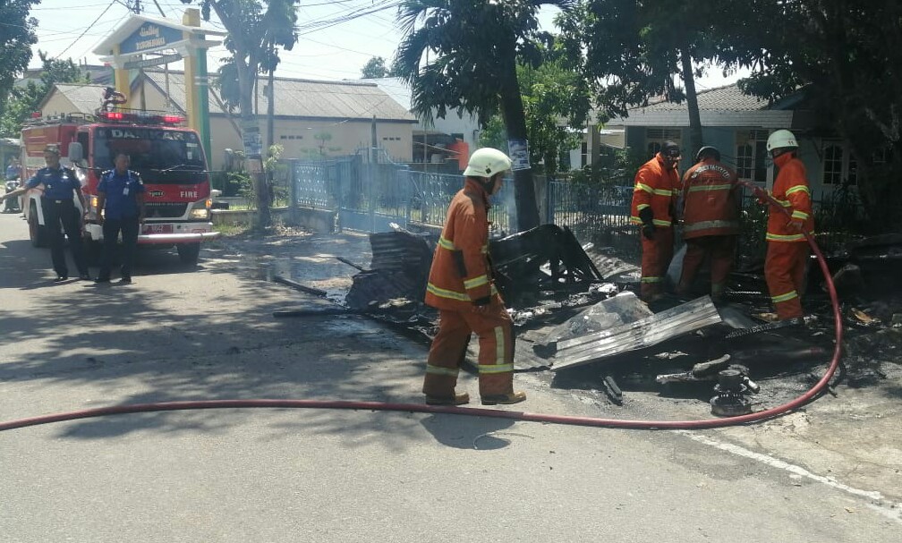 Petugas Damkar Kota Tanjungpinang terlihat memadamkan api di warung gorengan milik Sarinem yang terbakar, Rabu (18/12) siang