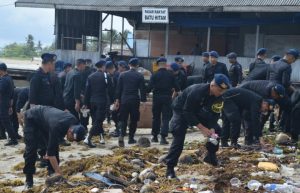Para personel Sat Brimob Polda Kepri tampak sedang memungut sampah di pantai sekitar Pasar Rakyat Batu Hitam.