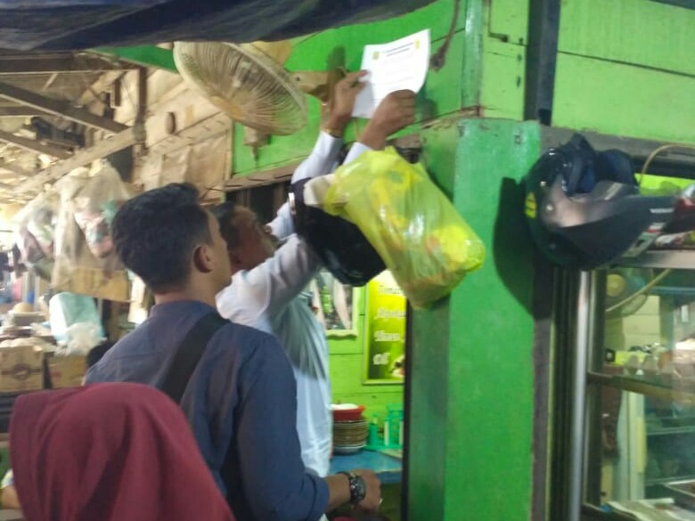 Seorang karyawan PT Tanjungpinang Makmur Bersama (TMB) BUMD Tanjungpinang terlihat menyegel kios pedagang "nakal" di salah satu kawasan pasar di Tanjungpinang, Senin (17/2).