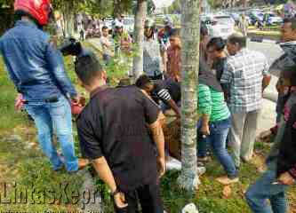 Warga sedang menolong dua siswi yang mengalami kecelakaan di Jalan Basuki Rahmad, (21/10)