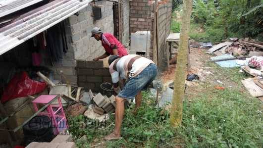 Terlihat kedua pekerja tengah membangun kamar mandi rumah Rina, penderita Stroke Neurologi, Senin (27/6).