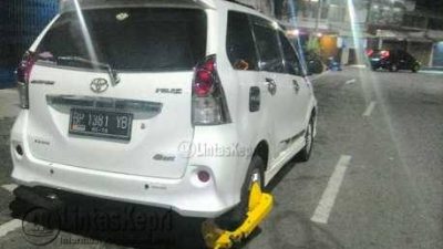 Avanza Veloz warna putih BP 1381 YB yang ditinggal pemiliknya digembok petugas Dinas Perhubungan Komunikasi dan Informatika (Dishubkominfo) Kota Tanjungpinang dikarenakan parkir sembarangan di Jalan Merdeka depan kedai kopi Pagi Sore.