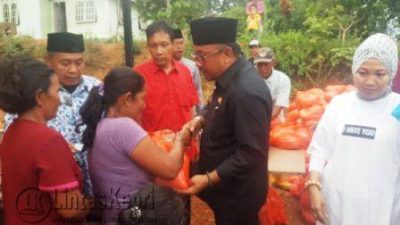 Walikota Tanjungpinang Lis Darmansyah dan Yuniarni Pustoko Weni (Kaos Putih) saat memberikan paket beras dan gula kepada warga yang membutuhkan, Jumat (4/11).
