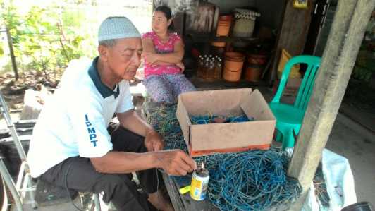 Keseharian Zahir saat membenahi peralatan budidaya rumput laut miliknya