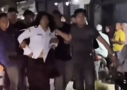 Seorang perempuan yang mengenakan seragam putih diduga guru terlihat berada di tengah kerumunan warga pada malam hari. Dok : Istimewa