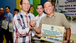 Wali Kota Batam, Amsakar Achmad, menyerahkan insentif saat menghadiri Silaturahmi bersama RT/RW, LPM, dan Tokoh Masyarakat se-Kecamatan Sekupang di Aula SMP Kartini Sei Harapan, Kecamatan Sekupang, Minggu (4/10/2026) malam. Dok : Diskominfo Kota Batam